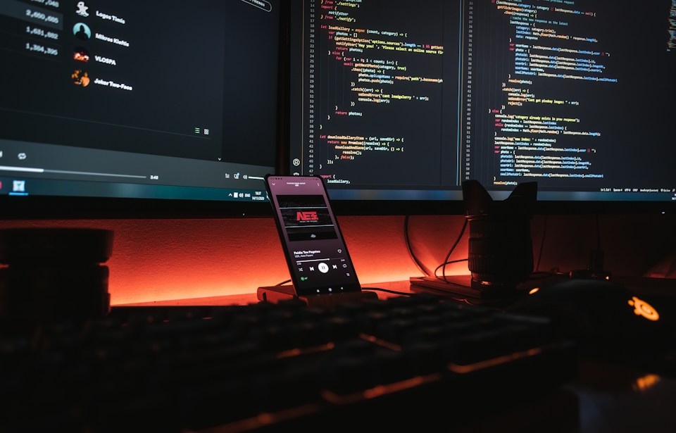 Software development workspace with code on computer monitors